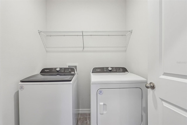 clothes washing area featuring washing machine and dryer and tile patterned floors