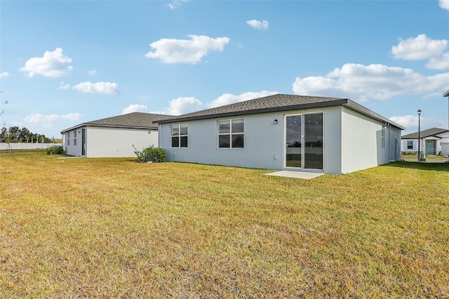 back of house featuring a lawn