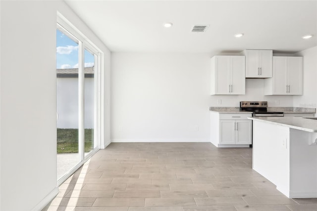 kitchen featuring white cabinets and stainless steel range with electric cooktop