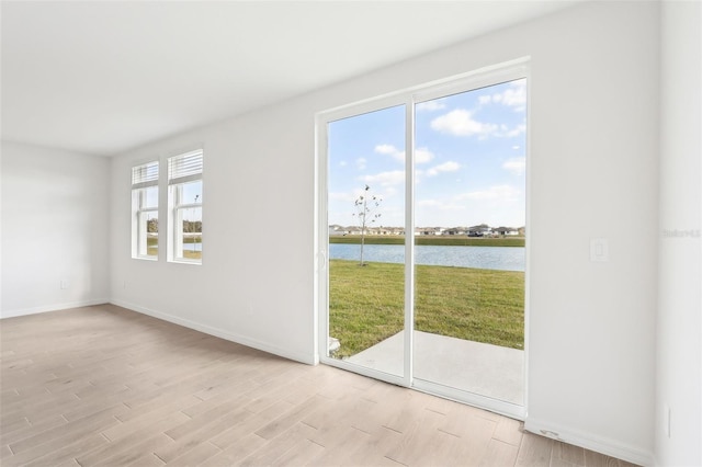 interior space with a water view and light wood-type flooring