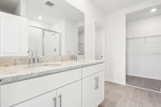 bathroom with vanity and a shower with door