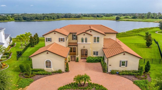 mediterranean / spanish-style home with a front yard and a water view