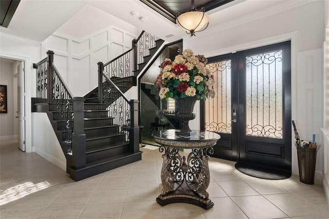 tiled entryway with french doors and crown molding