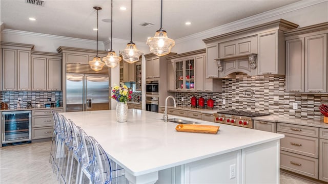 kitchen featuring wine cooler, sink, appliances with stainless steel finishes, and a kitchen island with sink