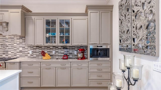 kitchen with ornamental molding, gray cabinetry, stainless steel appliances, and backsplash