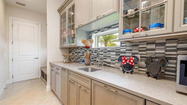 kitchen featuring sink, light tile patterned floors, and backsplash