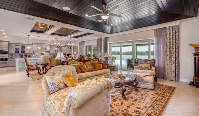 living room with a raised ceiling, ornamental molding, light tile patterned floors, and ceiling fan with notable chandelier