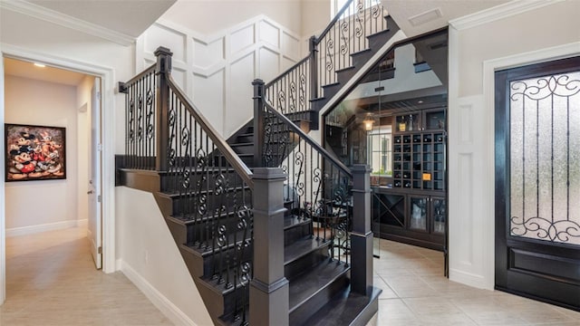 stairs featuring ornamental molding and tile patterned flooring