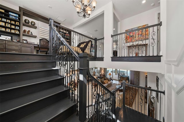 staircase with an inviting chandelier