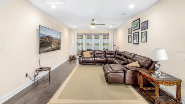 living room featuring dark wood-type flooring and ceiling fan