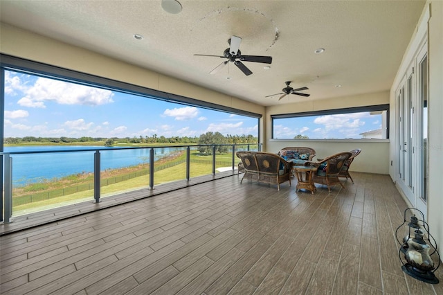 interior space with a water view and ceiling fan