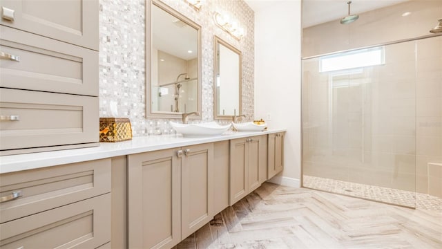 bathroom with vanity, tasteful backsplash, and tiled shower