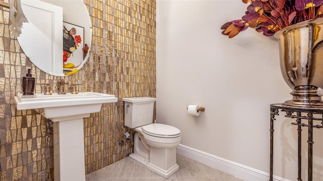 bathroom with tile walls, toilet, and tile patterned floors