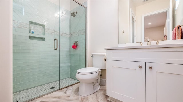 bathroom with vanity, a shower with shower door, and toilet