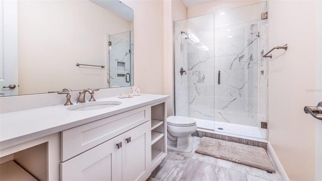 bathroom featuring a shower with door, vanity, and toilet