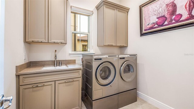 laundry area with cabinets, sink, washing machine and clothes dryer, and light tile patterned floors