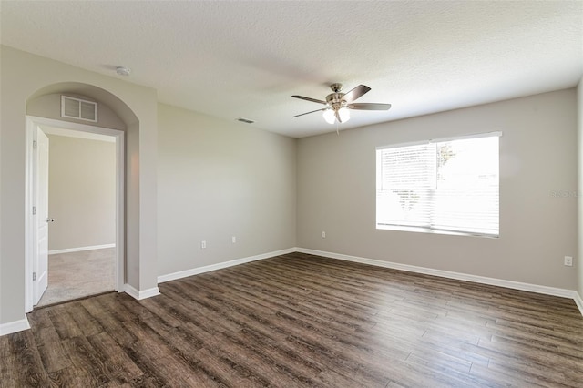 empty room with ceiling fan, a textured ceiling, and dark hardwood / wood-style flooring