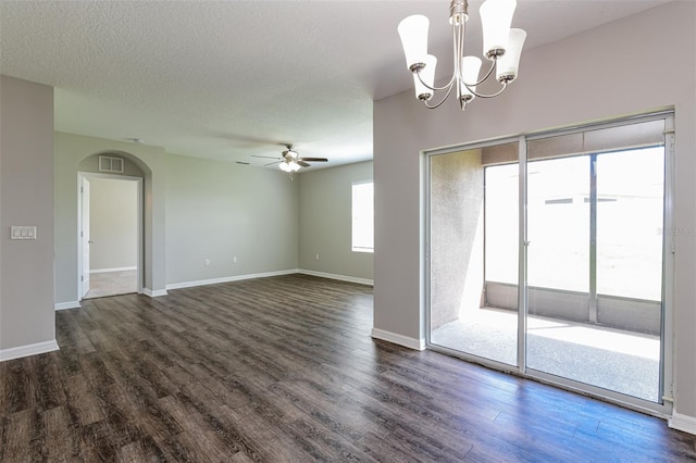 empty room featuring a textured ceiling, dark wood-type flooring, and ceiling fan with notable chandelier