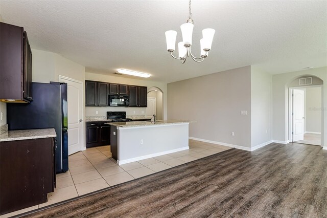 2036 Van Buren Loop, Auburndale, FL 33823 - kitchen featuring black appliances, arched walkways, light wood-style floors, a sink, and a chandelier