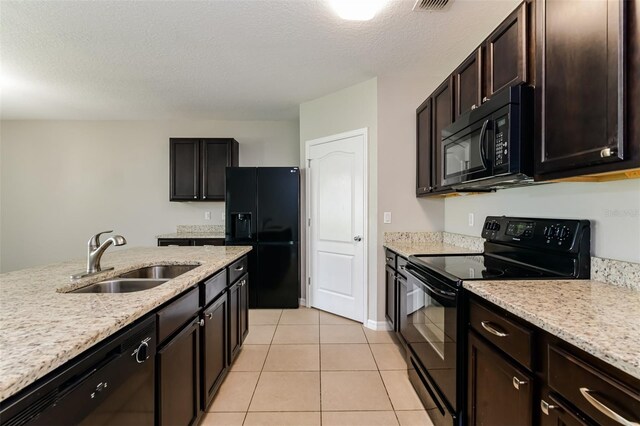 2036 Van Buren Loop, Auburndale, FL 33823 - kitchen featuring black appliances, a sink, light tile patterned flooring, light stone countertops, and dark brown cabinets