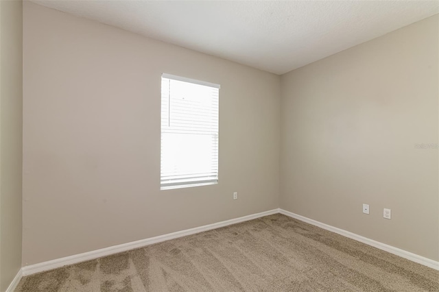 carpeted spare room featuring a healthy amount of sunlight