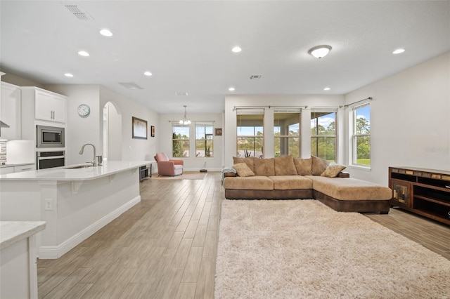 living room with sink and light wood-type flooring