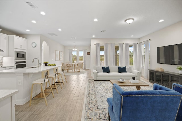 living room featuring sink and light wood-type flooring