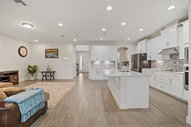 kitchen with white cabinetry, stainless steel appliances, and light wood-type flooring