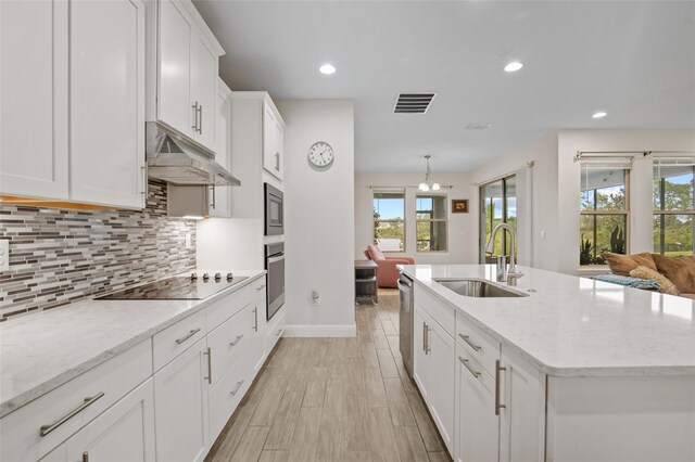 kitchen featuring a center island with sink, sink, white cabinetry, and stainless steel appliances