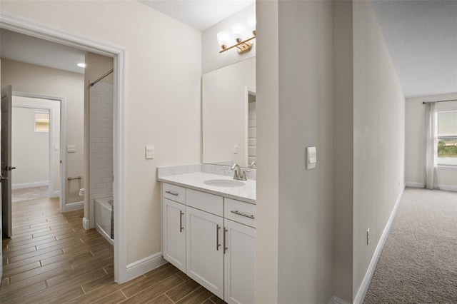 bathroom with vanity, tiled shower / bath combo, a textured ceiling, and hardwood / wood-style floors