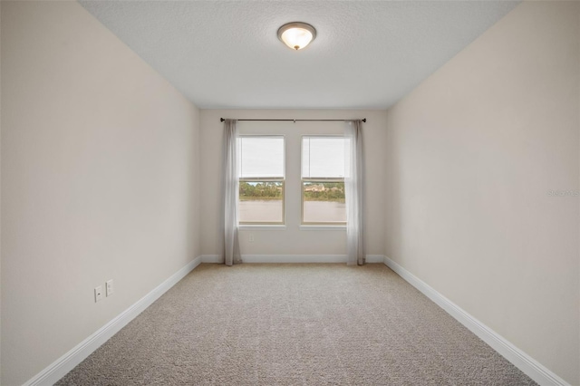 carpeted empty room with a textured ceiling