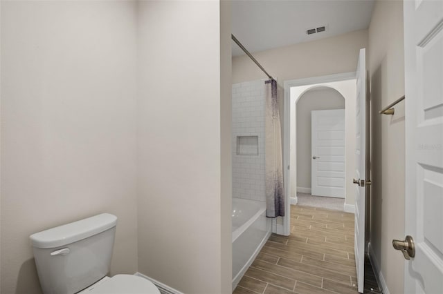 bathroom with toilet and shower / tub combo with curtain