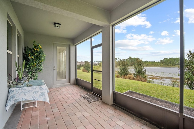 unfurnished sunroom with a water view