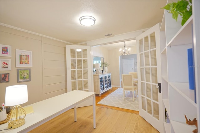 office featuring ornamental molding, hardwood / wood-style floors, a notable chandelier, and french doors