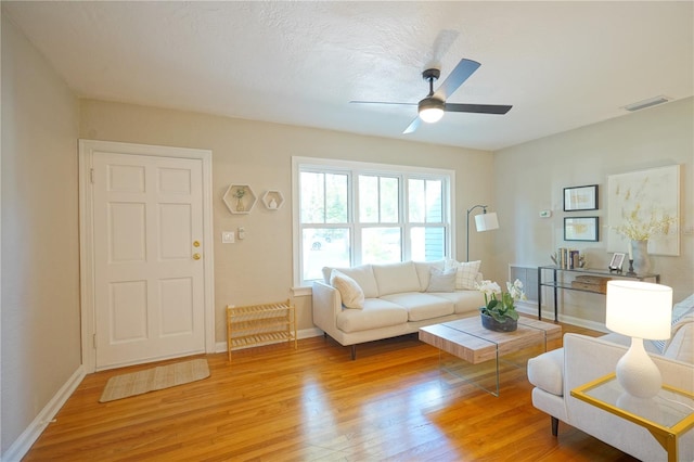 living room featuring ceiling fan and light hardwood / wood-style flooring