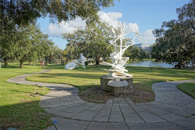 view of property's community with a water view and a lawn