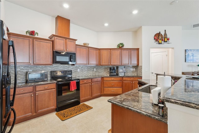 kitchen with dark stone countertops, sink, black appliances, light tile patterned floors, and tasteful backsplash