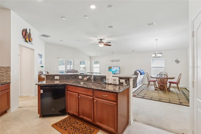 kitchen with sink, dishwasher, lofted ceiling, dark stone counters, and decorative light fixtures