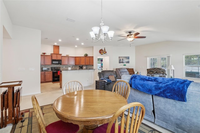 carpeted dining area with lofted ceiling and ceiling fan with notable chandelier