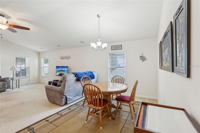 dining room featuring vaulted ceiling, light carpet, and ceiling fan with notable chandelier