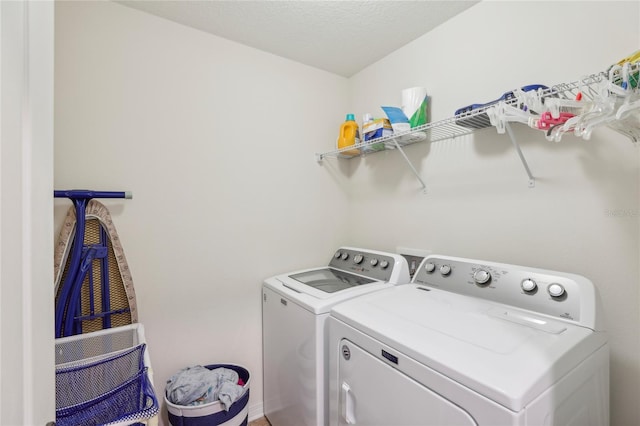 laundry area with a textured ceiling and washing machine and clothes dryer