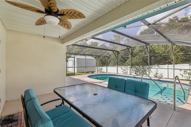 view of swimming pool with a patio, a lanai, and ceiling fan