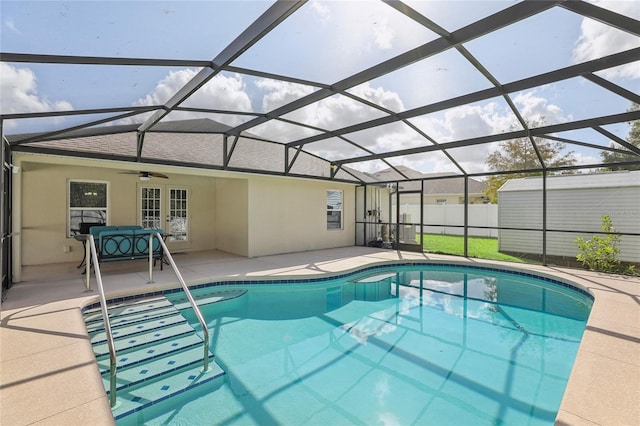 view of swimming pool featuring ceiling fan, glass enclosure, and a patio area