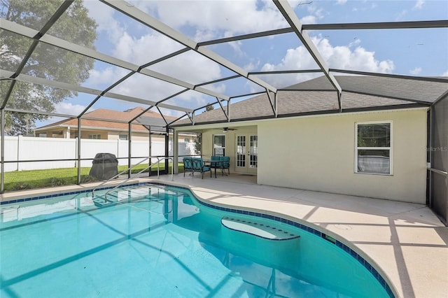 view of pool with french doors, ceiling fan, a lanai, and a patio