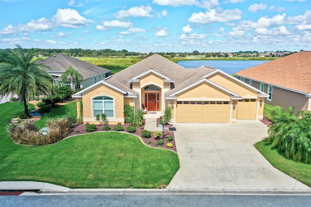 view of front facade with a garage, a front lawn, and a water view