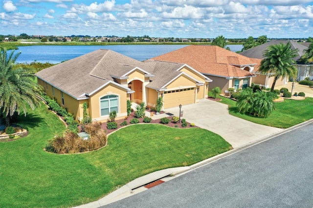 view of front facade with a front yard, a garage, and a water view