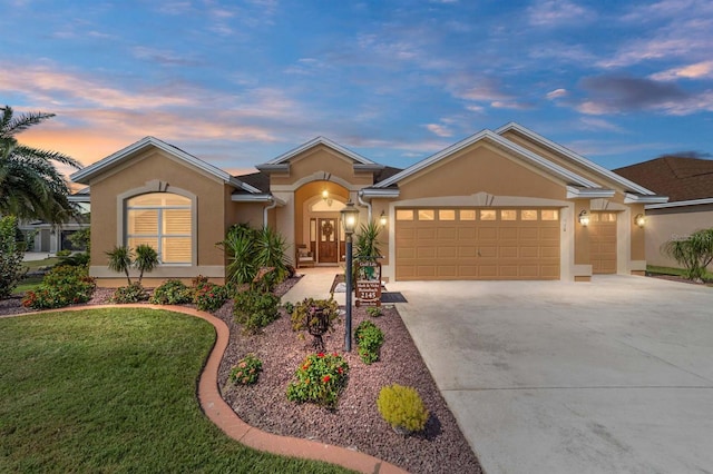 ranch-style home with a garage and a lawn