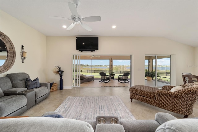 living room with ceiling fan, a healthy amount of sunlight, vaulted ceiling, and light tile patterned floors