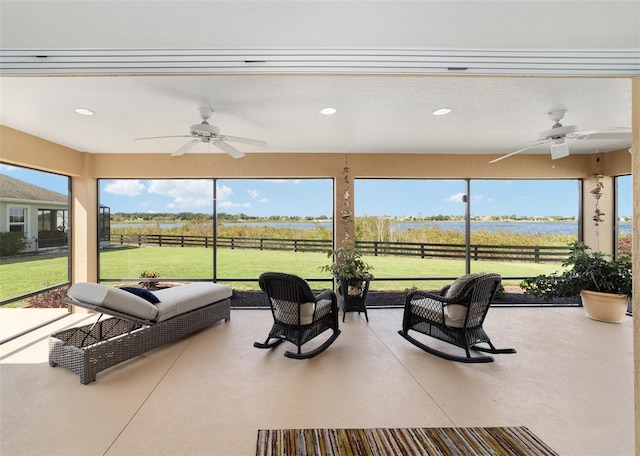 sunroom / solarium with a rural view, a healthy amount of sunlight, and ceiling fan