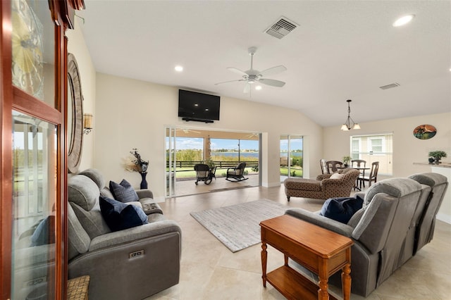 tiled living room with lofted ceiling and ceiling fan with notable chandelier